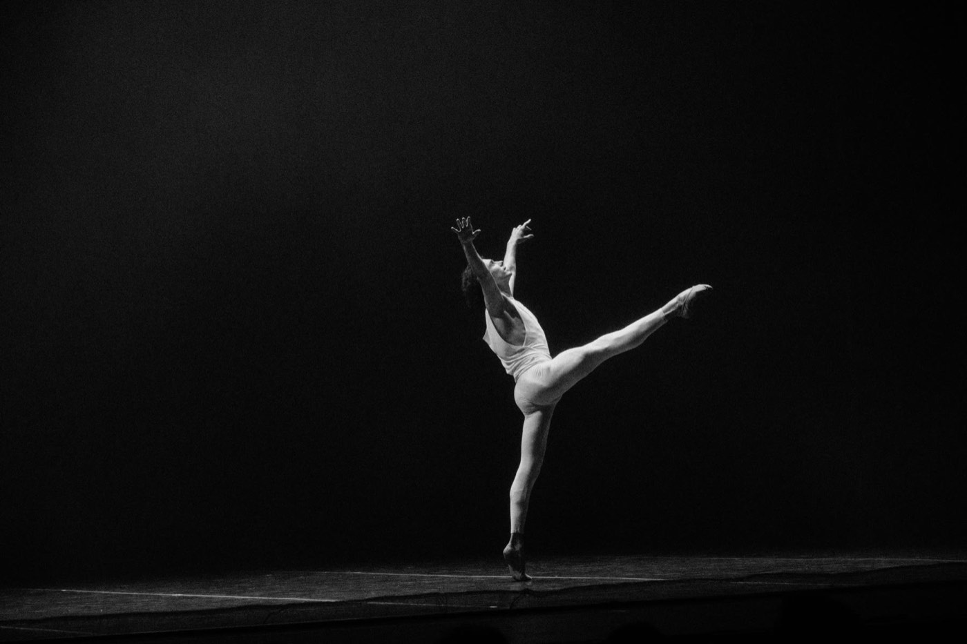 Dancer balancing under a stage light