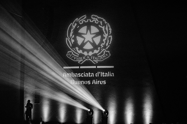 Fasci di luce sotto una proiezione istituzionale nel teatro