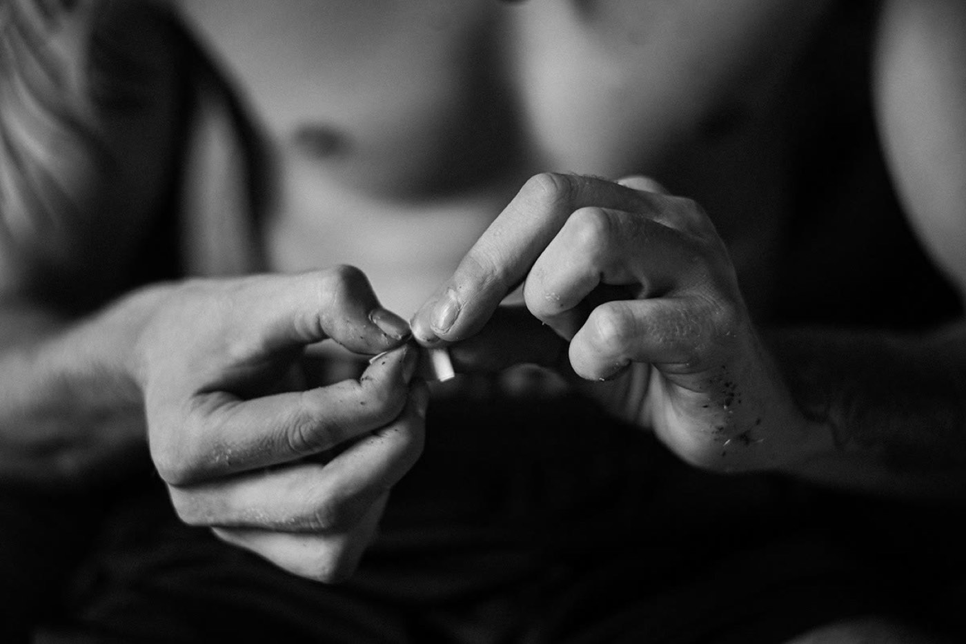 Hands working on a small object in black and white