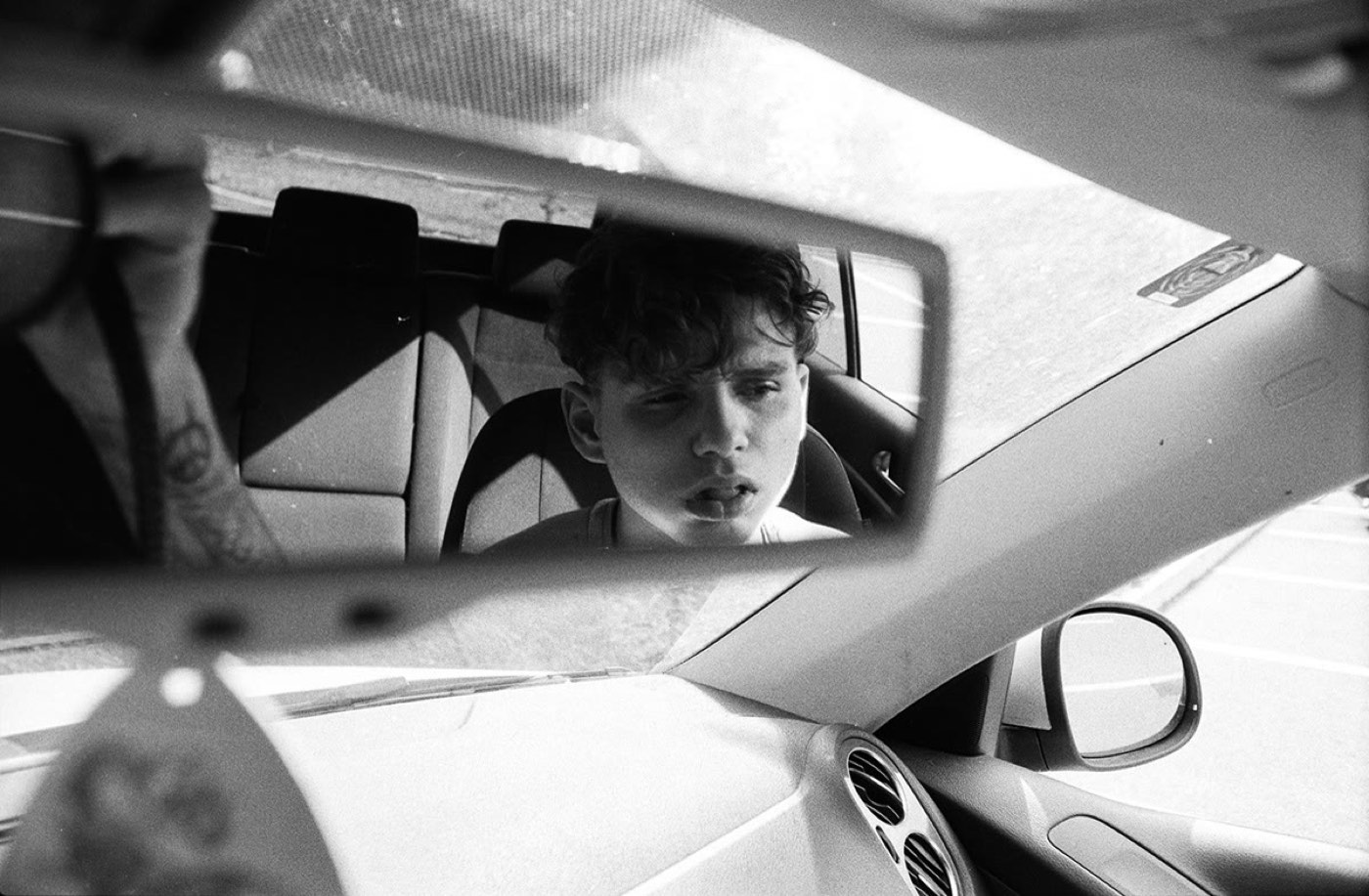 Face reflected in a car mirror in black and white